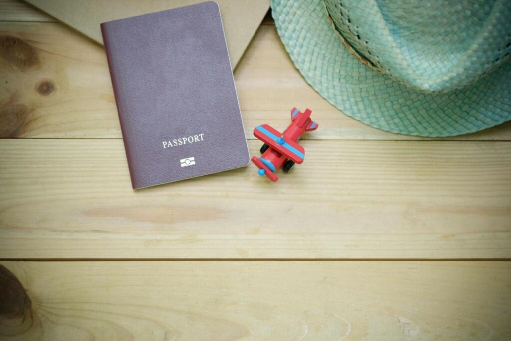 A passport on a wooden surface with a toy plane